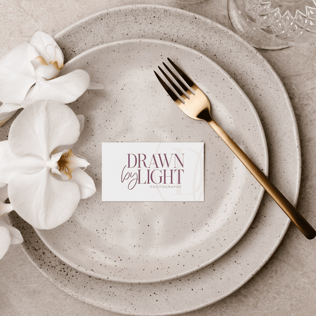 Primary logo for a wedding photography on a card laid on top of wedding table plate