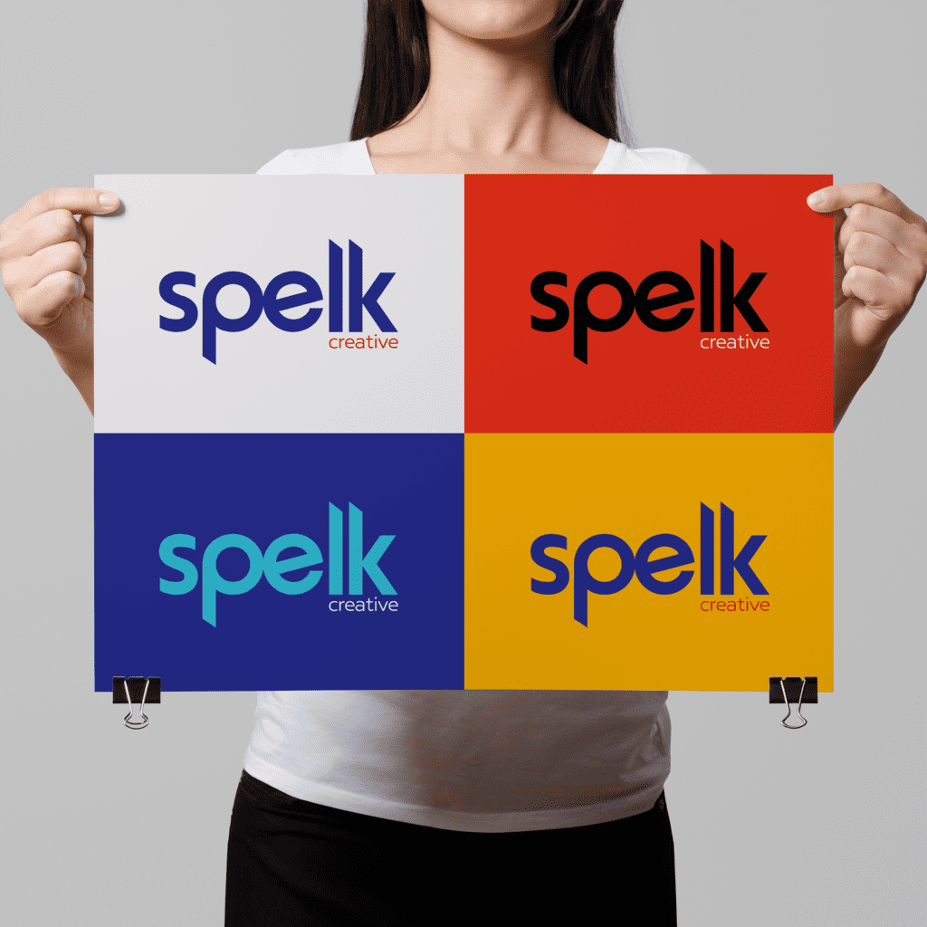 Woman holding a page with logos designs for a motion graphics company in bright bold red, orange and blue colour palette
