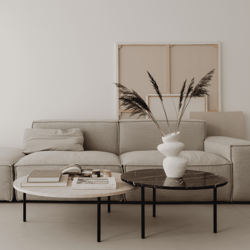 Interior Design of room with modern beige sofa with coffee tables and minimalist vase and books