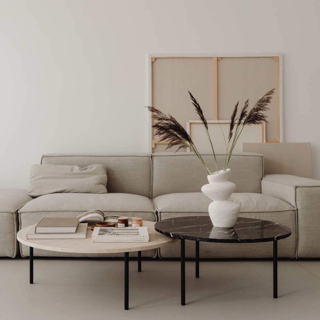 Interior Design of room with modern beige sofa with coffee tables and minimalist vase and books