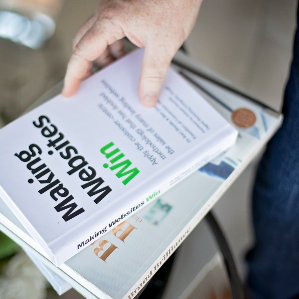 Hand holding the book Making Websites Win – inspiration for successful web design projects