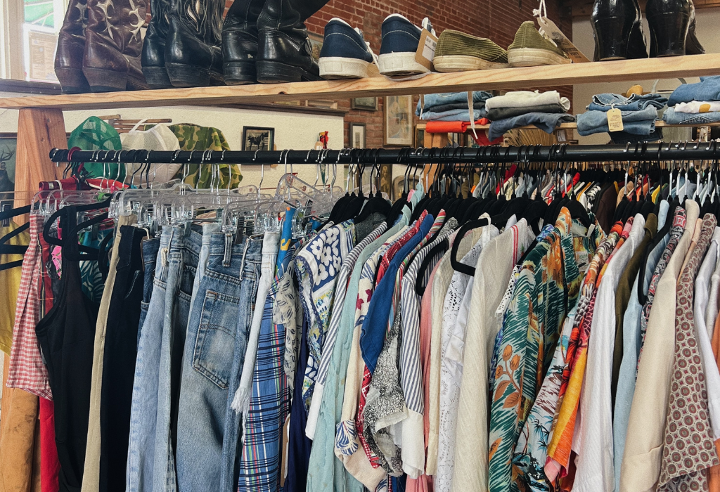 Charity shop rail of clothing and shoes for sale